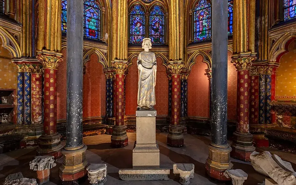 A decorated interior and stained-glass windows of Sainte-Chapelle in Paris.