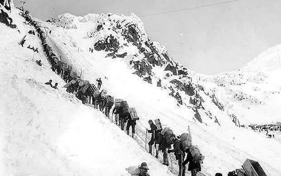 Gold-rush travelers carrying supplies up Chilkoot Pass in 1898