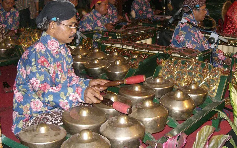 A musician playing an instrument in a gamelan ensemble