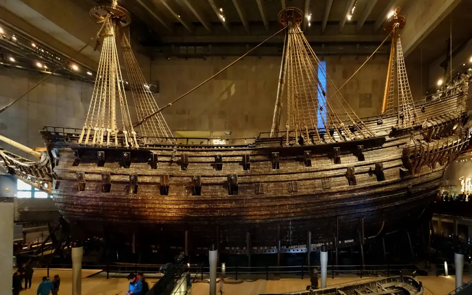 Cropped side view of the preserved warship Vasa in its Stockholm museum; the source panorama has a museum pillar digitally removed