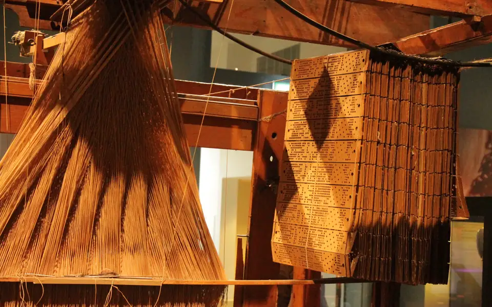 A Jacquard loom and its hanging chains of punched cards at the National Museum of Scotland