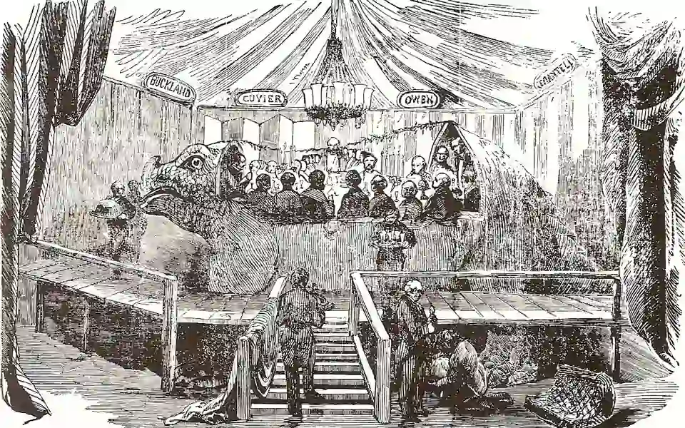 An 1854 engraving depicts the New Year’s Eve 1853 banquet inside the Iguanodon model at Crystal Palace, with diners, waiters and a chandelier